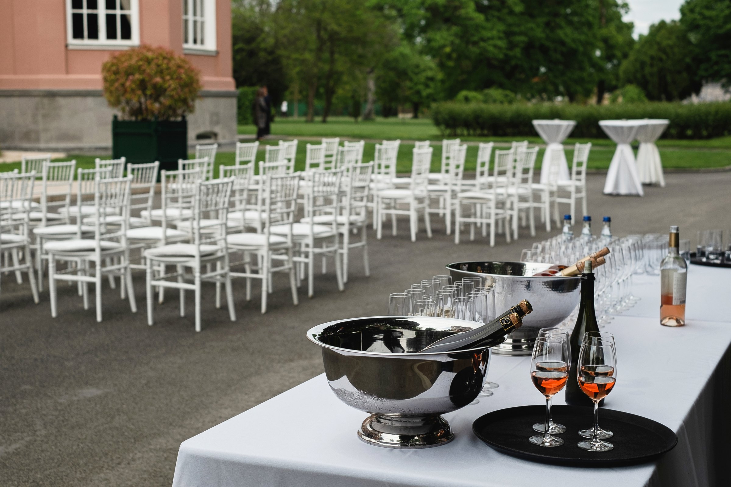 White ceremony chairs and a champagne table on the palace lawn