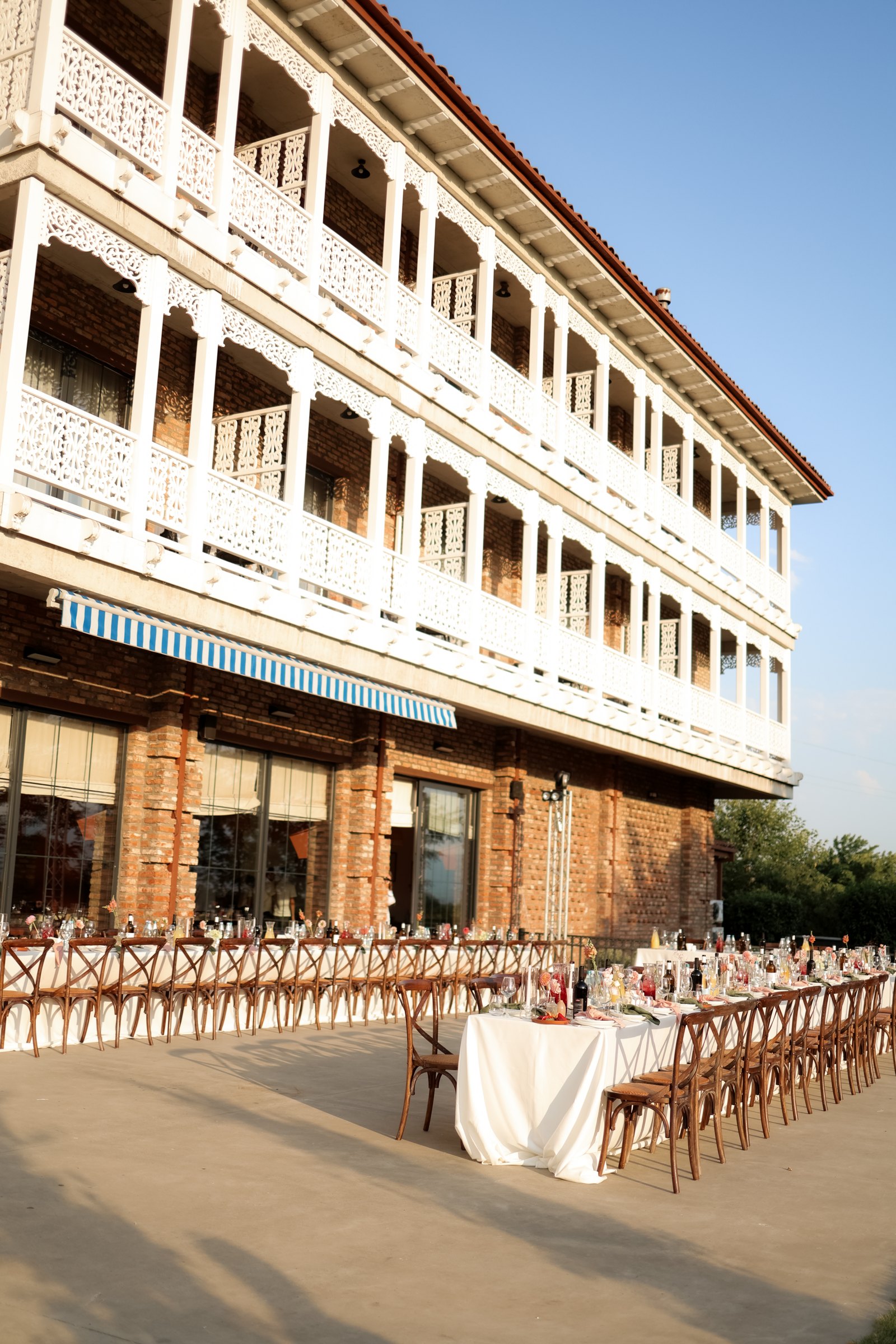 Single long banquet table on the Chateau Artwine terrace before the wedding dinner