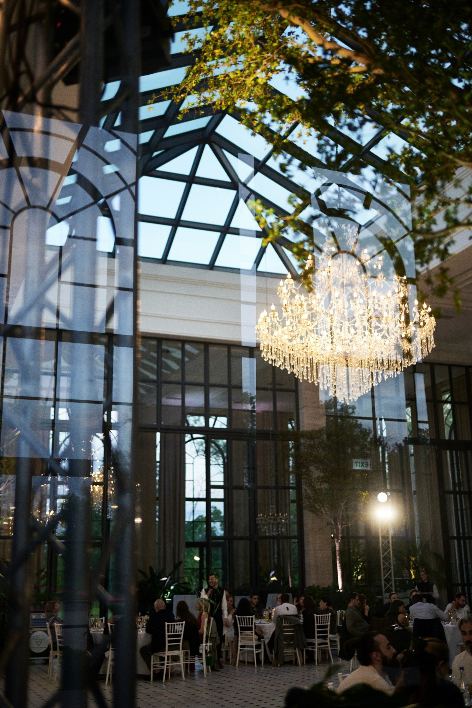 Wedding dinner in the glasshouse under a chandelier