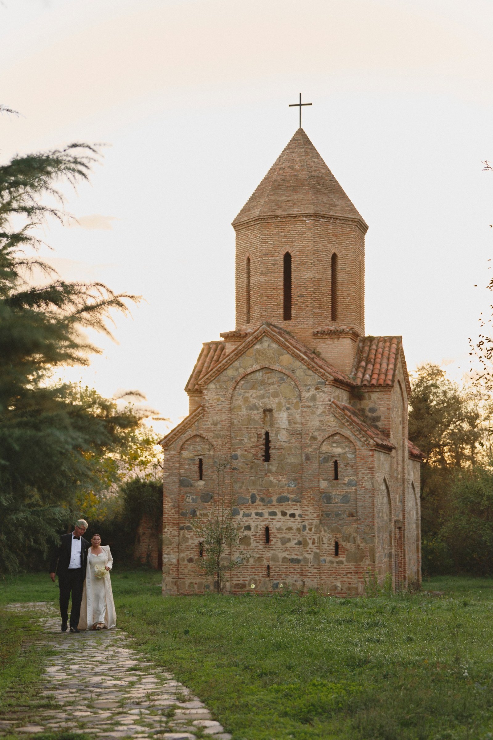 The couple walks to an ancient stone church near the estate