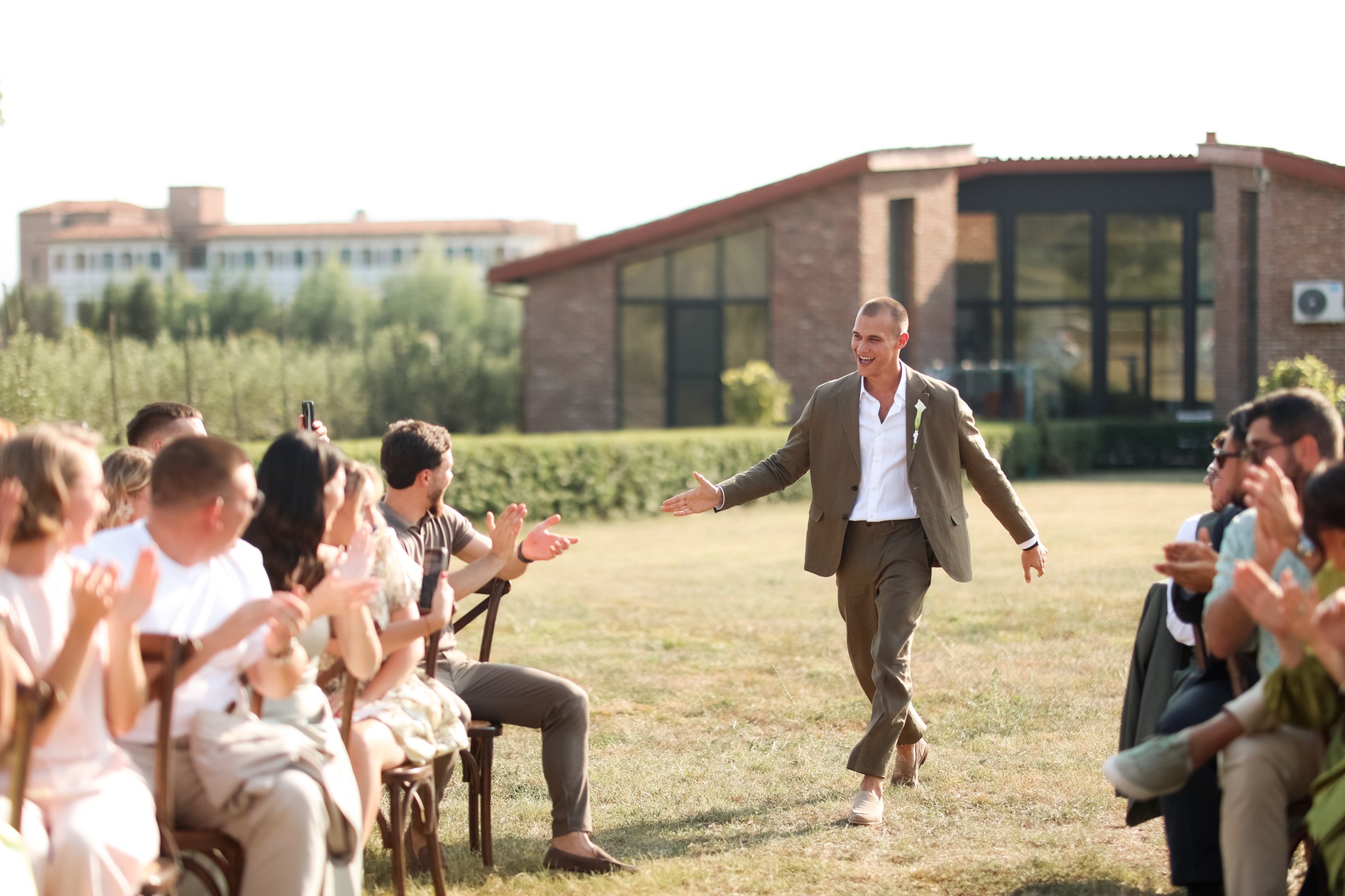 The groom walks in to applause