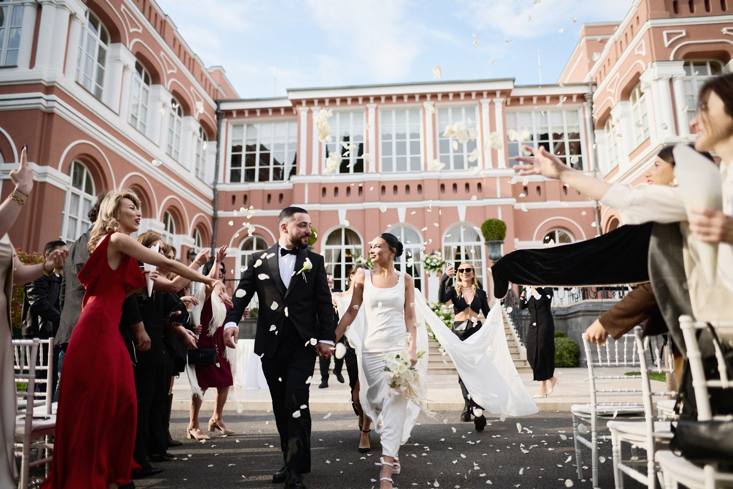 Back up the aisle through petals, the palace behind