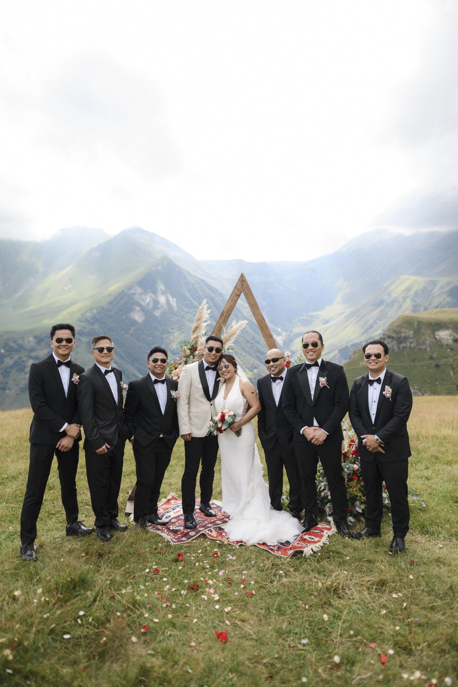 The whole wedding at the arch, petals in the air