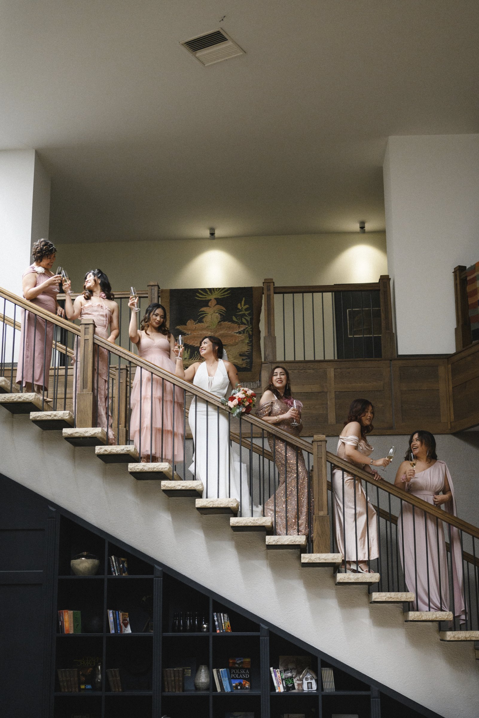 The bridesmaids in dusty pink descend the staircase