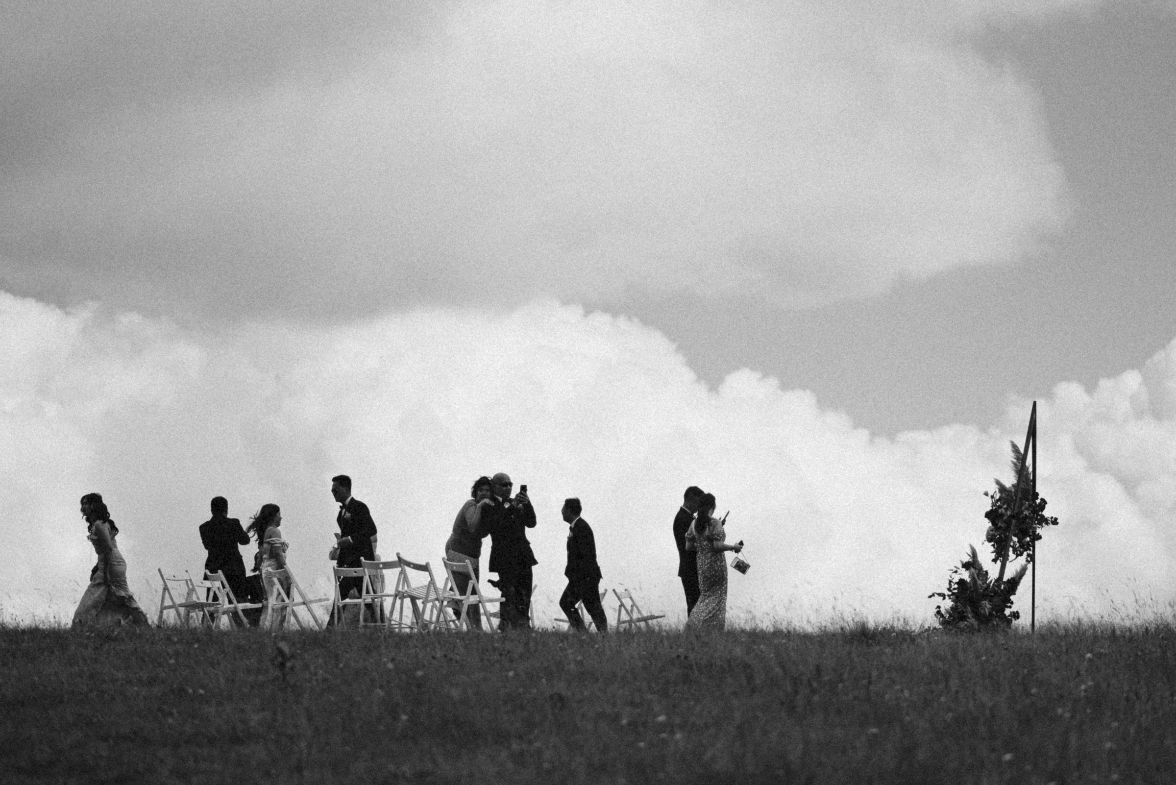 The wedding party small against the clouds, black and white