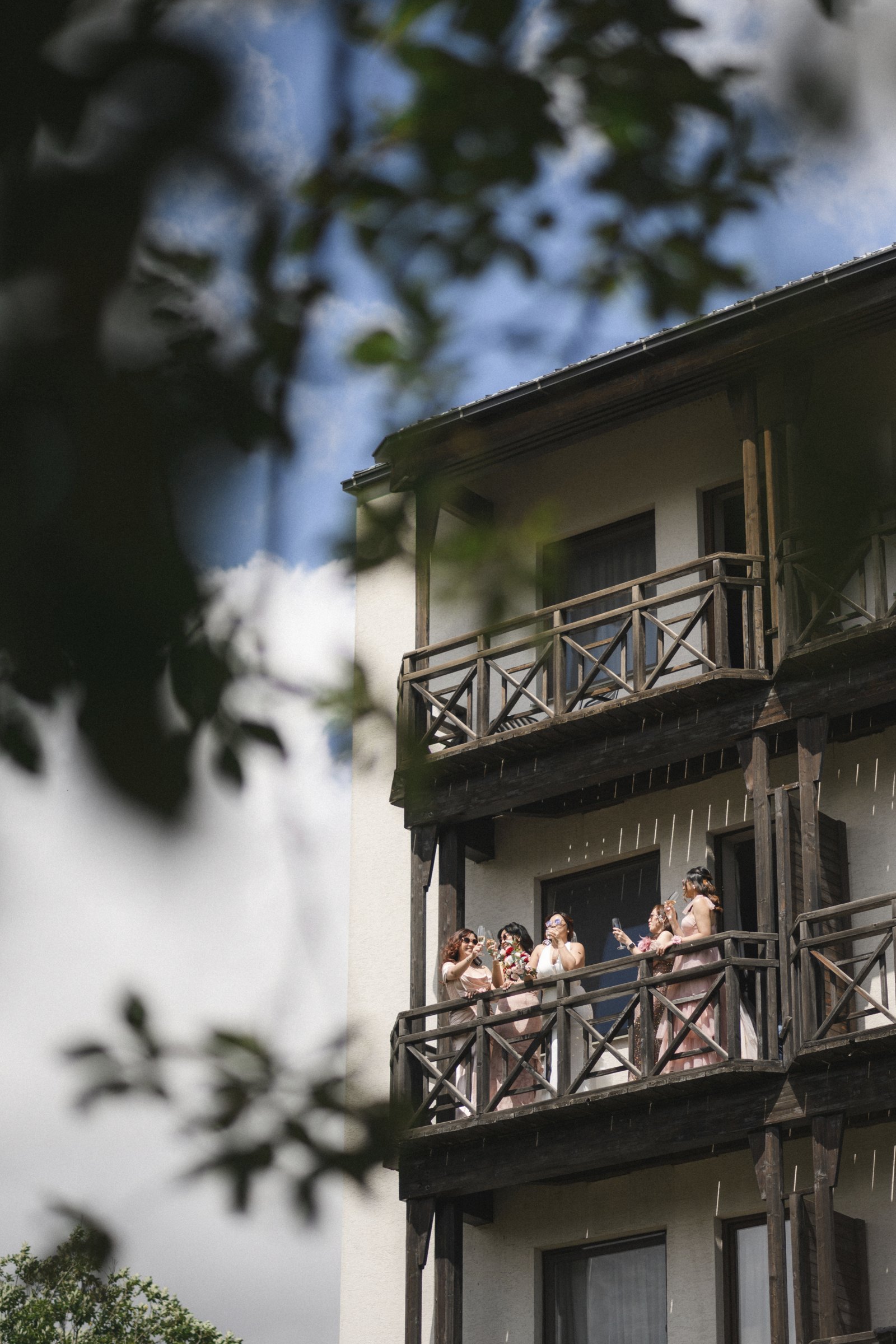 The bridesmaids watch from the hotel balconies