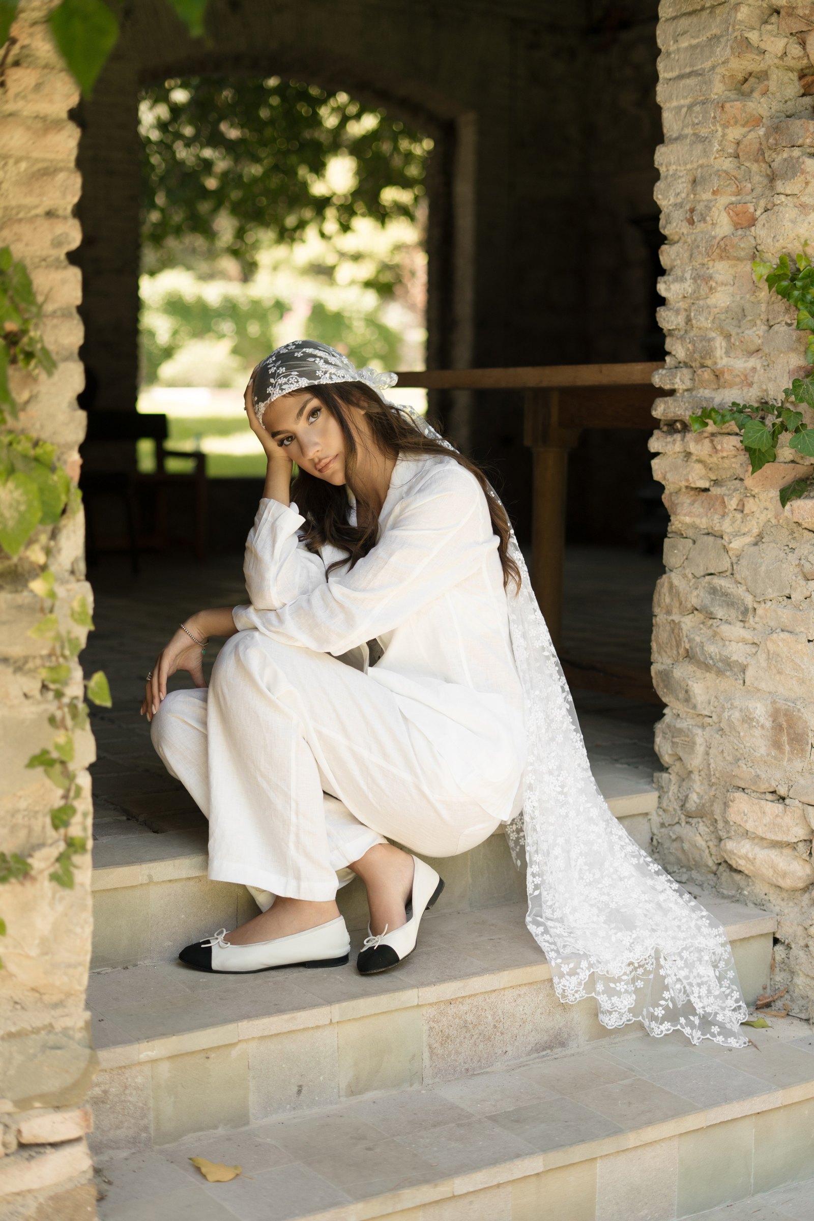 The bride at the old stone arch of the estate