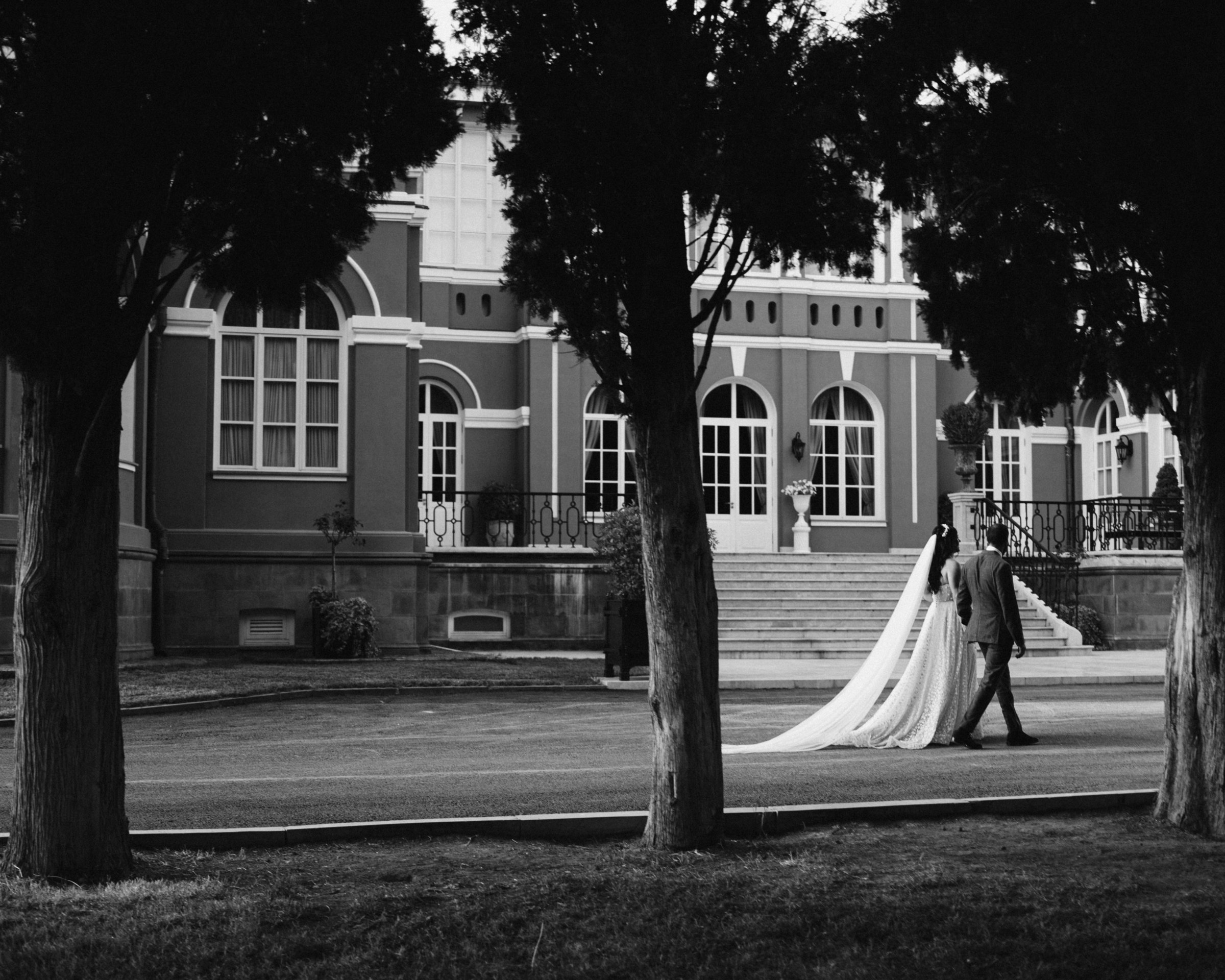 The palace and the couple between the trees, black and white